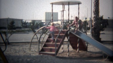1979: Dad and son go down metal playground slide in tandem.