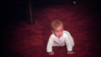 1979: Baby cry hiding face in red carpet, turtling from the world.
