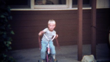1979: Cute blond boys 1st tricycle ride around driveway.