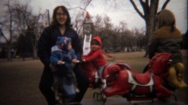 1974: Mom's play with children on rotating merry go round.
