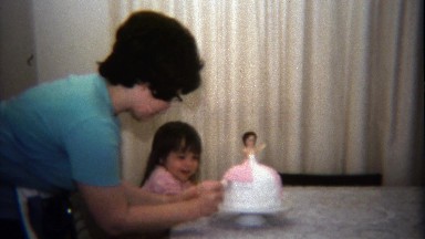 1974: Mother daughter sharing princess cake making moment together.