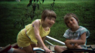 1973: Cute twin girls smiling at summer family reunion outdoor event.