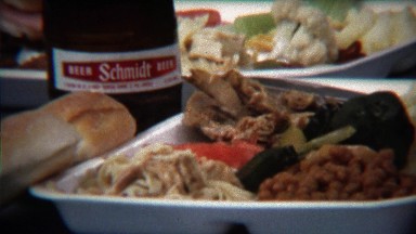 1973: Plate full of food next to Schmidt beer bottle at outdoor picnic.