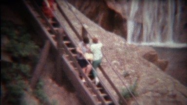 1972: Women having trouble climbing steep outdoor staircase.