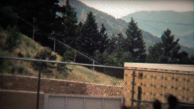 1972: Giraffe head closeup at zoo walking in modern concrete habitat.