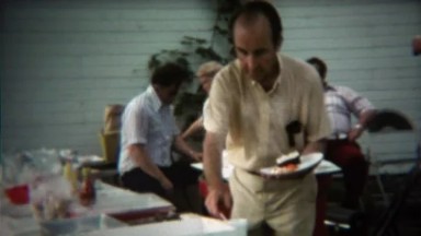 1973: Mature man getting extra cake at summer family reunion picnic.