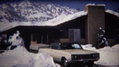 1972: 70's Dodge car parked in snowy mountain house driveway.