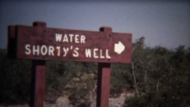 1972: Shorty's water well oasis in middle of dry scrub bush desert.