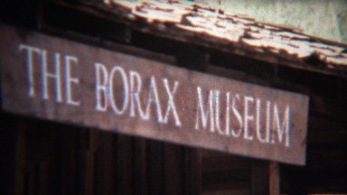1972: Borax mining museum ruins with rusted wagon train carts.