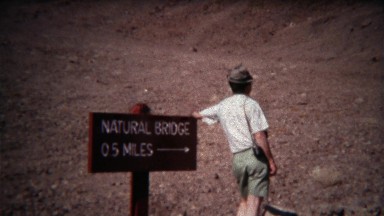 1972: Man Pointing to Natural Bridge Attraction Half Mile from Sign