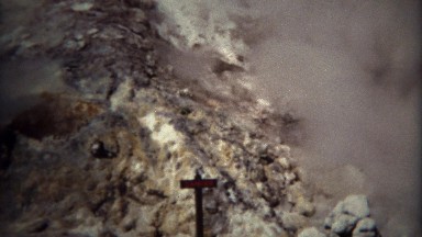 1971: Danger sign with hot volcanic steam rising wasteland.