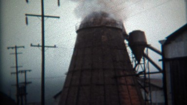 1971: Steam rising from industrial factory lumber mill processing plant.