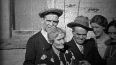 1933: Extended family petting family car outside of depression era home.