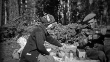 1933: Couple having outdoor picnic pouring hot coffee from canteen.