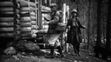 1934: Couple leaving rural log cabin for vacation fishing spot.