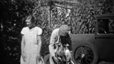 1934: Man wearing necklace of hunted dead geese around neck.