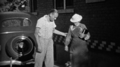 1935: Blue collar gentleman escorting formal fancy women with dog.