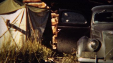1939: Hunting trip car and canvas style camping tents.