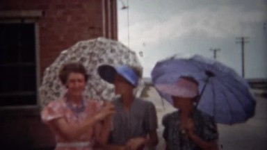1940: Fashionable Women with Sun Umbrellas and Colorful Dresses in Denver