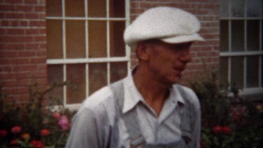 1940: Overalls Man Talking to Fedora-Wearing Gentleman in Denver Backyard