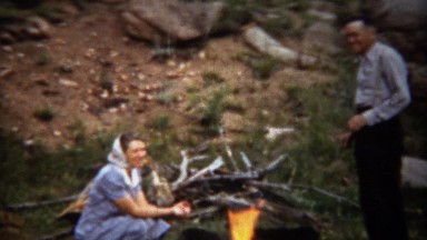 1940: Couple Warming by Campfire in Formal Fashion Dress