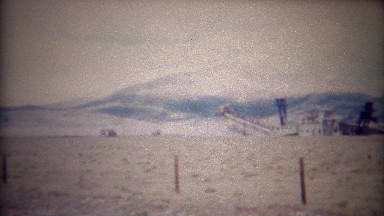 1956: Abandoned Bucket Line Gold Mining Dredge in Mountainous Region