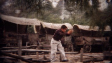1956: Boy exploring old western stagecoach amphitheatre exhibit.