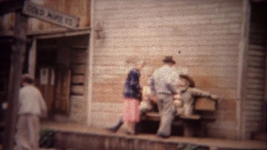1956: Couple sitting with old timey mining mannequin statue figures.