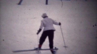 1949: Woman having trouble snow skiing duck walking uphill.