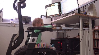 Toddler on professional 3 monitor computer server business workstation.