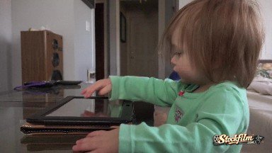 Denver, Colorado, United States: Toddler Tablet Computer Taps and Swipes Closeup on Coffee Table.