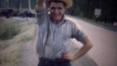 1949: Rural Man Holding Wild Snake as Classic Car Drives By