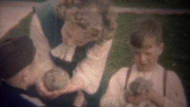 1949: Kids playing with baby bunny rabbits with mother supervision.