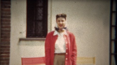 1942: Pretty women with 40's pink cardigan sweater and hair curled.