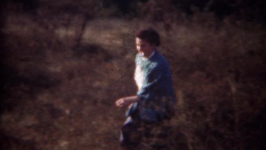 1944: Woman smoking cigarette in coming out of dry autumn forest.