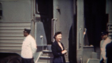 1947: Woman smoking outside Pullman railroad train before entering.