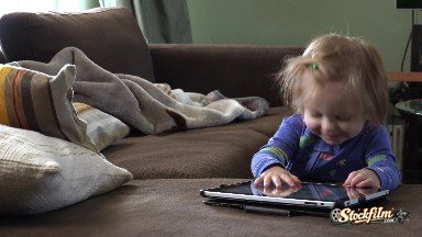 Toddler Gets Distracted From Tablet Computer In Blue Pajamas. Denver, Colorado
