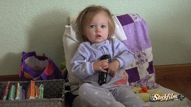 Baby Blue Pajamas Holding TV Remote Controller Seated With Books. Denver,