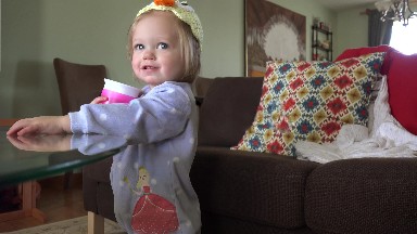 Baby with homemade duck hat drinking from pink sippy cup. DENVER, COLORADO