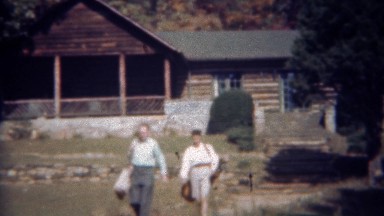 1945: Couple Leaving Log Cabin Going Golfing Carrying Golf Bags, Tryon, NC