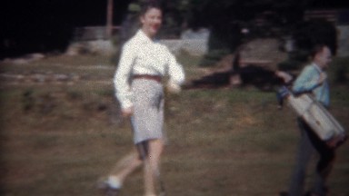1945: Woman Golfer and Caddy Carry Clubs Down Fairway in Tryon, NC