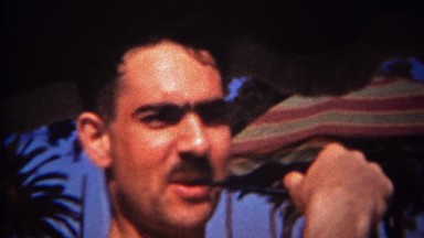 1944: Hispanic mustache man smoking pipe palm tree umbrella background. TRYON,