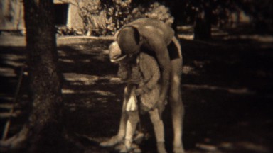 1937: Dad teaching daughter crocette sport hitting ball with game mallet. TRYON,