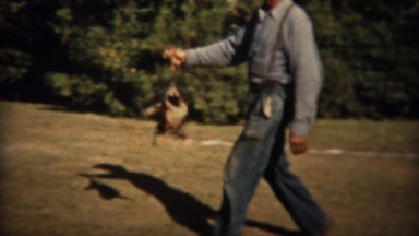 1937: Man carries wild opossum animal by tail with girl watching. TRYON, NC