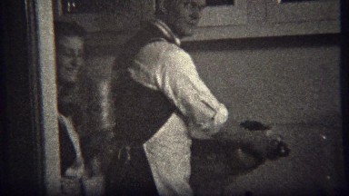 1944: Man begrudgingly washes dishes in kitchen to women's delight. MIAMI,