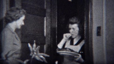 1944: Women brings out food plate from kitchen with permanent curl hair style.