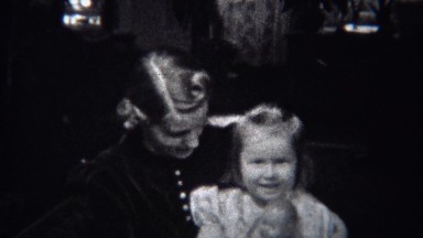 1944: Mother daughter rocking chair with baby doll and big smiles. MIAMI,