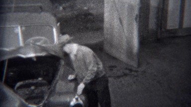 1944: Man inspecting hood opened car engine of classic Buick car. MIAMI,