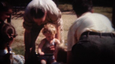 1944: Kids play on seesaw park toy ride with help of father parents. SAN DIEGO,
