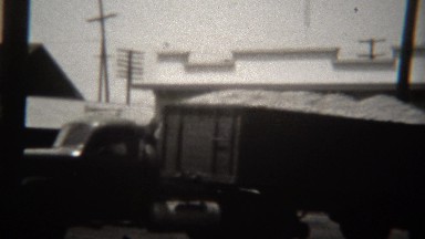 1946: Semi truck with 2nd cart carries overloaded oranges down street. VILLA